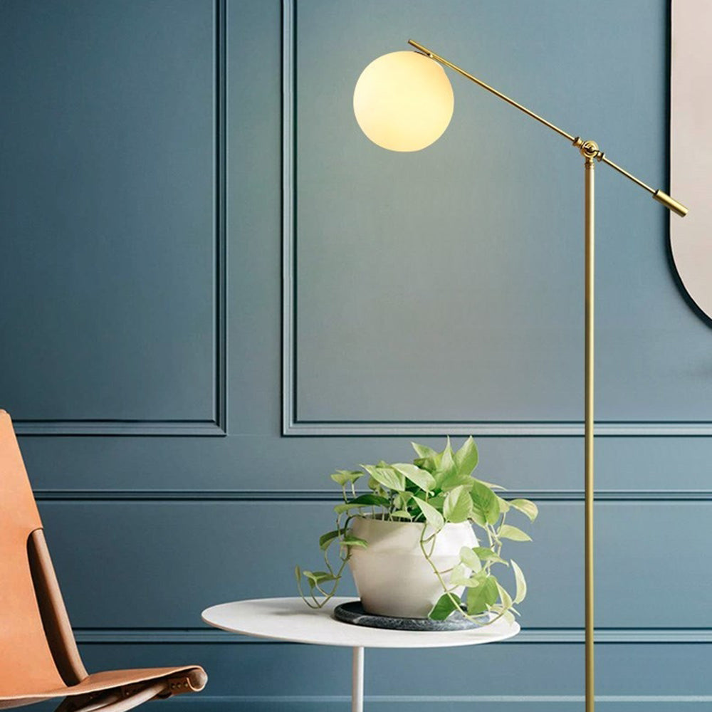 Lámpara de pie dorada con globo de cristal Vemira en un salón moderno – imagen 3