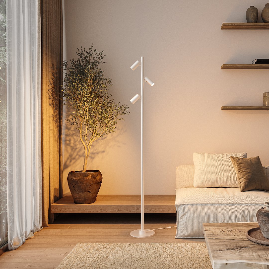 Lámpara de pie LED con focos magnéticos Rielta – en blanco junto a un olivo