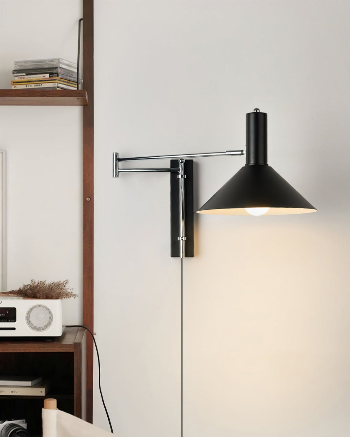 Aplique de pared articulado Brazola junto a un sillón de lectura – imagen 4