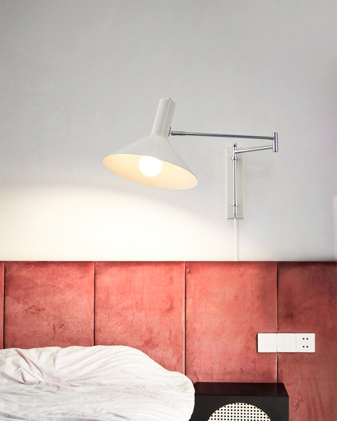 Aplique de pared articulado Brazola junto a un sillón de lectura – imagen 7