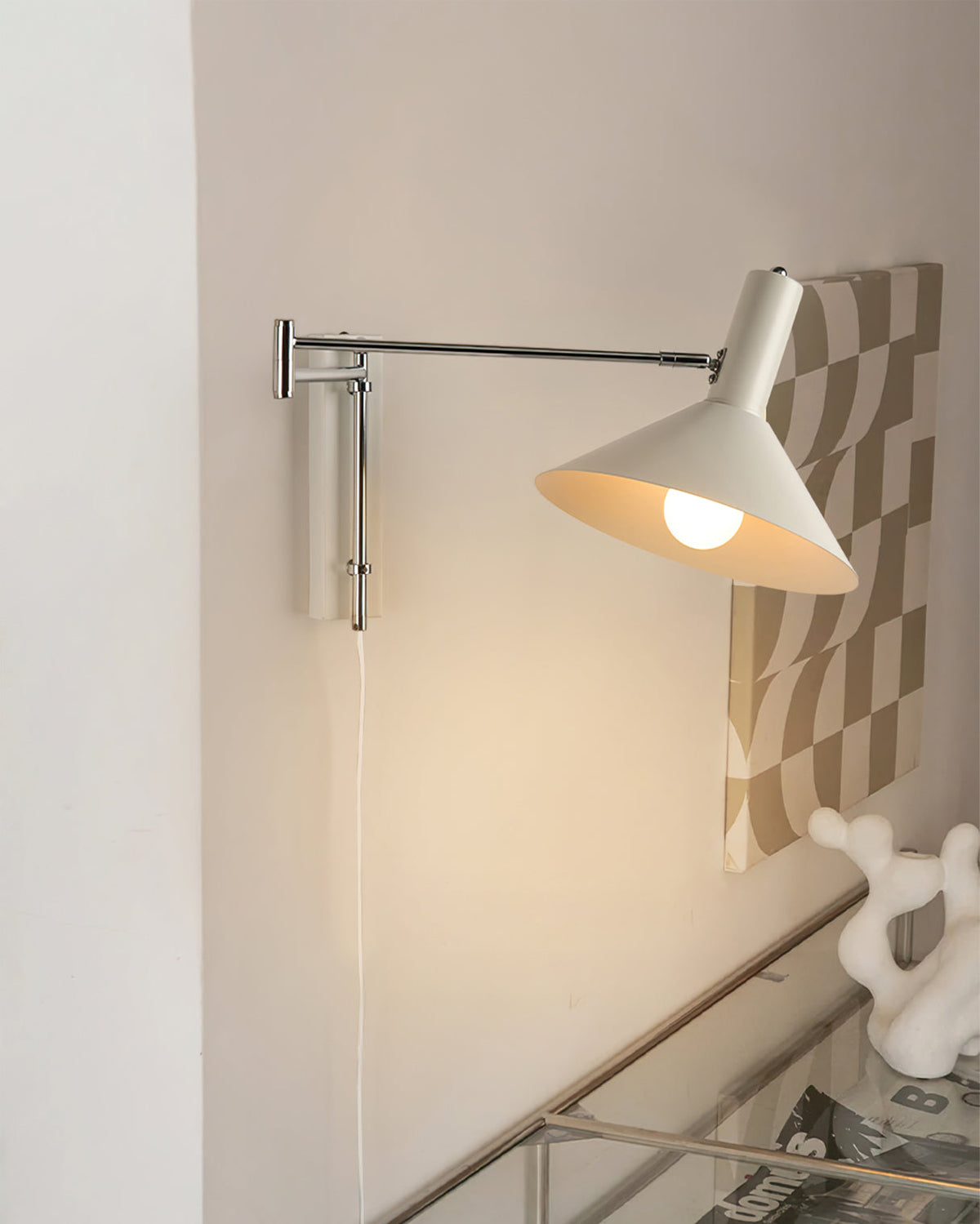Aplique de pared articulado Brazola junto a un sillón de lectura – imagen 10