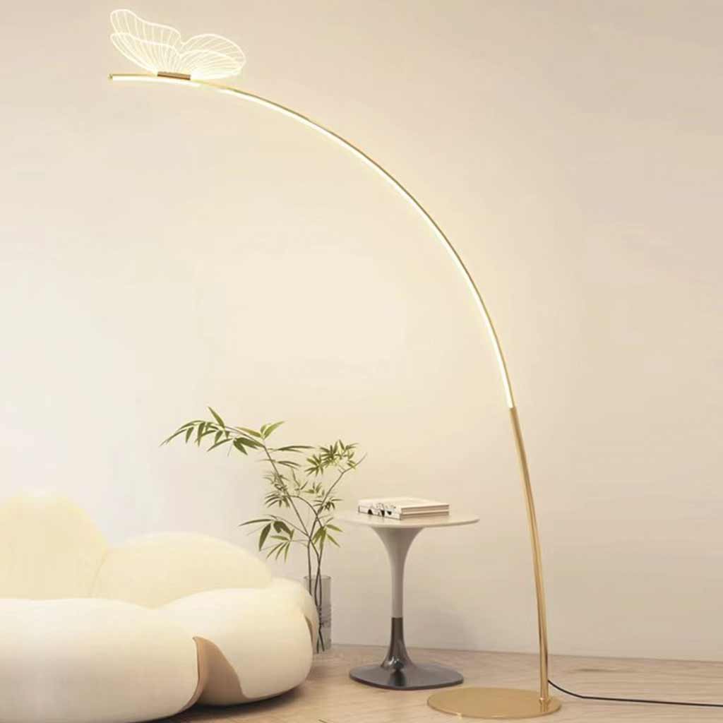 Lámpara de pie de arco con mariposa Sualeta – junto a un sofá blanco