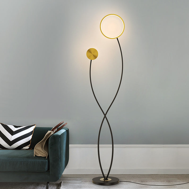Lámpara de pie LED Solenta – encendida junto a un sofá verde