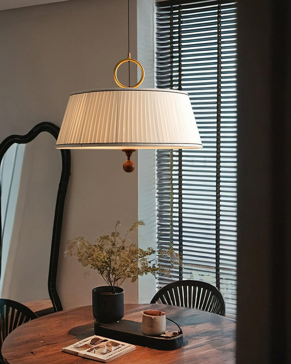 Lámpara colgante con pantalla plisada Jovela sobre una mesa de comedor – imagen 8