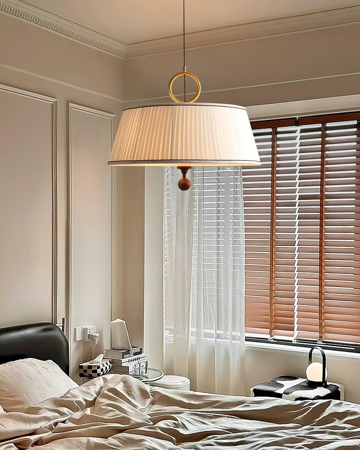 Lámpara colgante con pantalla plisada Jovela sobre una mesa de comedor – imagen 9