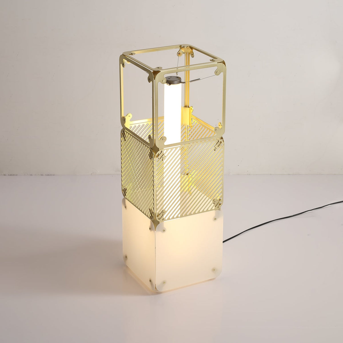 Lámpara de pie modular LED con cubos dorados y difusor blanco Sorina – de 68,5 cm encendida junto a la pared