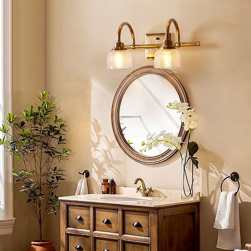 Aplique de pared Yarela con cristal estriado y latón – versión de 2 luces sobre un espejo de baño