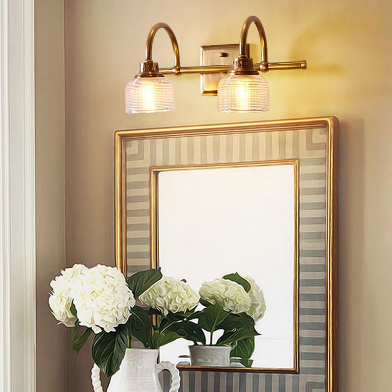 Aplique de pared Yarela con cristal estriado y latón – versión de 2 luces sobre un espejo