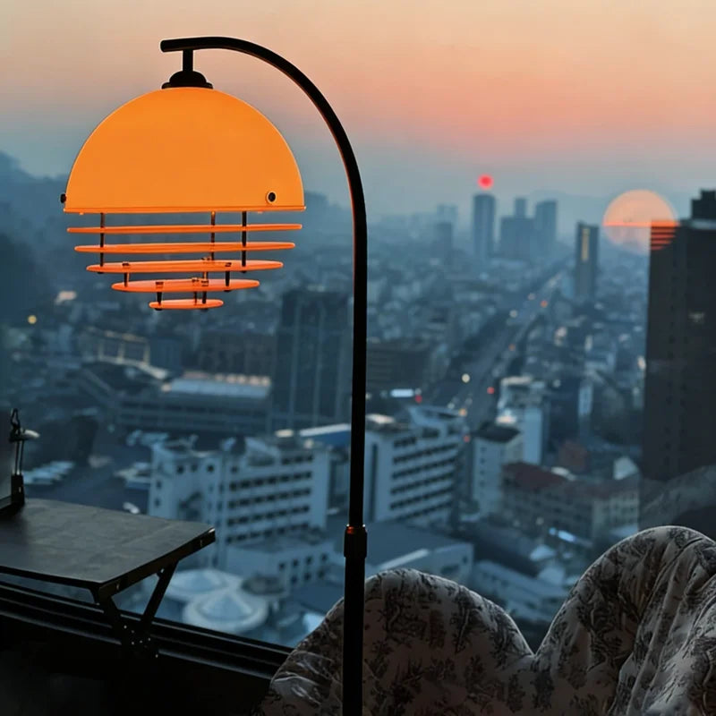 Lámpara de pie arqueada Velasol – con la pantalla iluminada al atardecer
