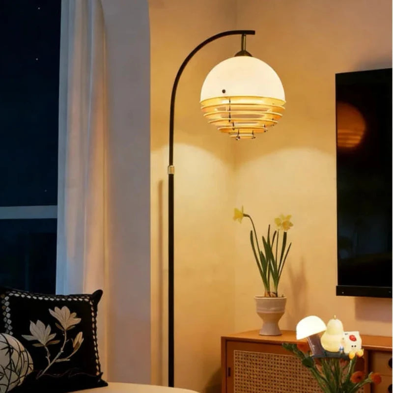 Lámpara de pie arqueada Velasol – encendida en un salón cálido