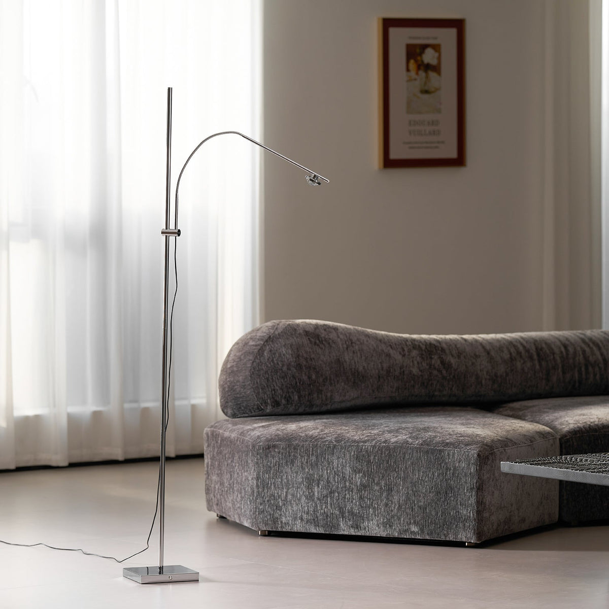 Lámpara de pie LED arqueada Vareta – junto a un sofá gris en un salón luminoso