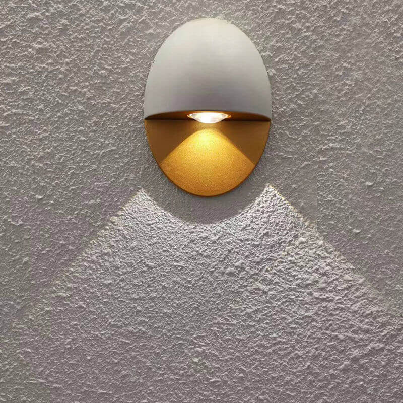 Aplique de pared exterior Yolena ovalado – blanco y dorado proyectando un haz de luz
