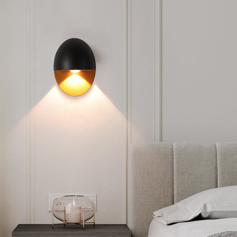 Aplique de pared exterior Yolena ovalado – negro y dorado junto a la cama