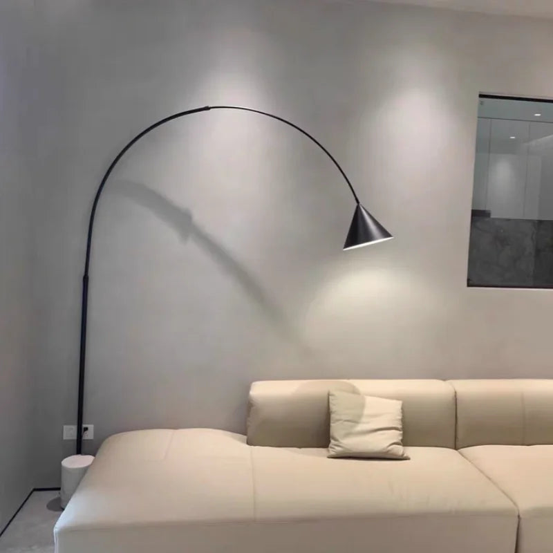 Lámpara de pie de arco Sauceda – de 200 cm sobre un sofá blanco