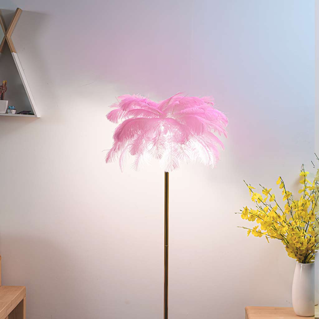 Lámpara de pie de plumas Truzela – rosa encendida junto a un jarrón de flores