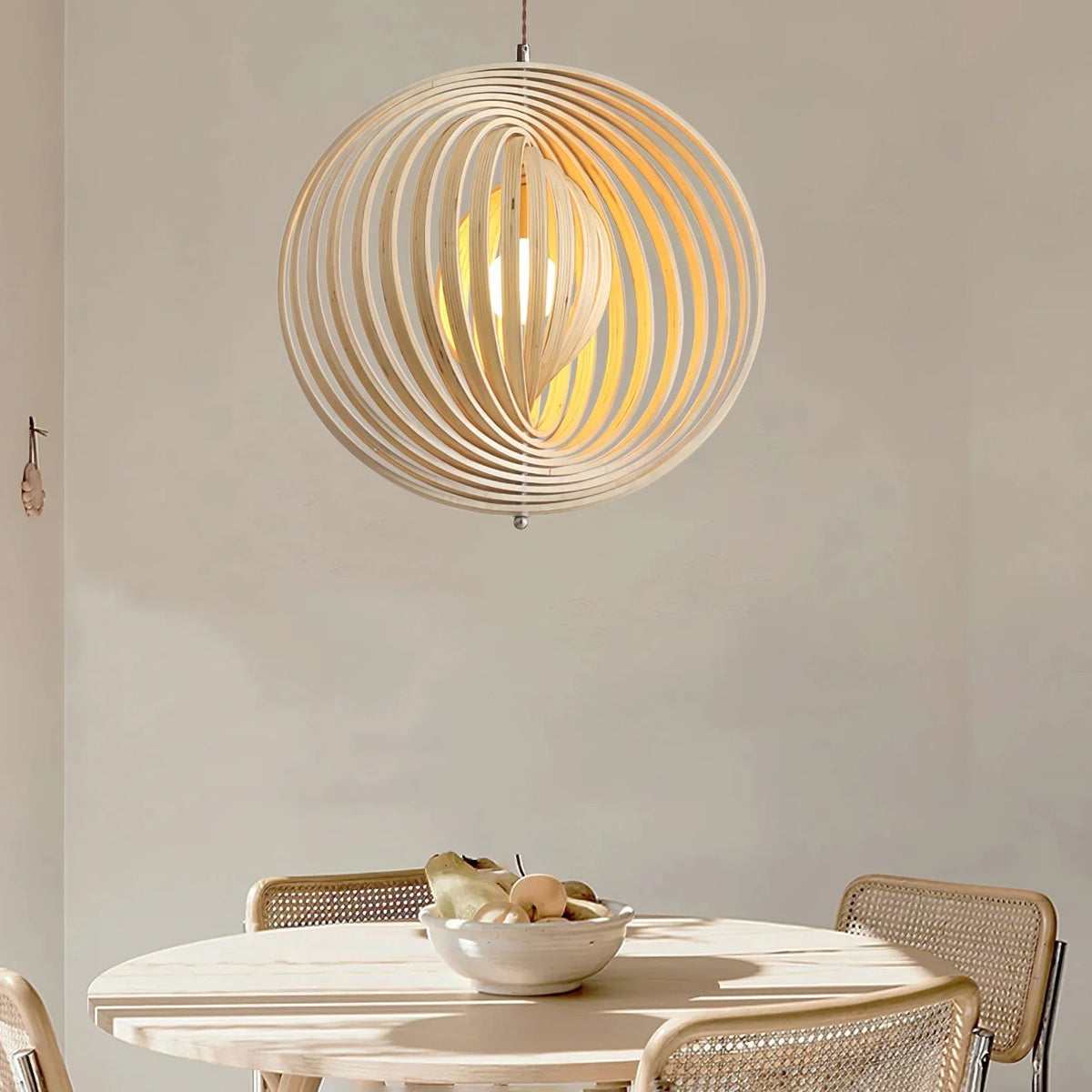 Lámpara colgante esfera de láminas de madera Aluma sobre una mesa de comedor – imagen 2