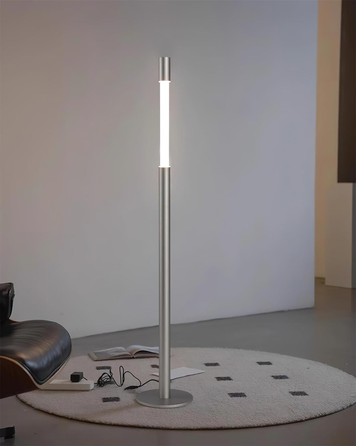 Lámpara de pie LED columna Tizona – plateada sobre una alfombra