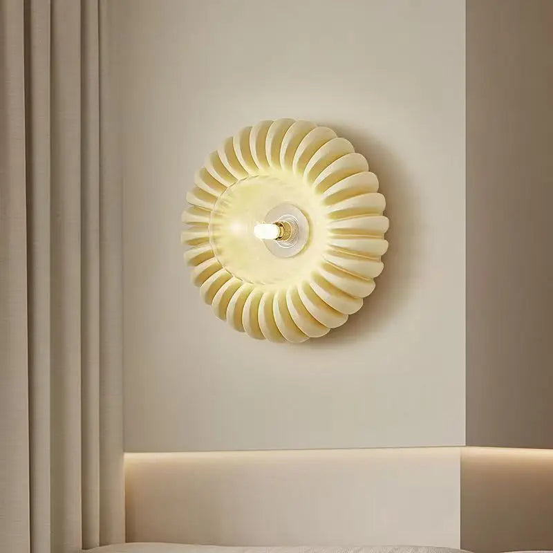 Aplique de pared en forma de flor Zinela – con cristal transparente sobre la cama