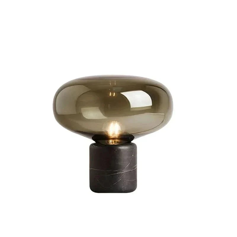 Lámpara de mesa de mármol y cristal Kupola – con globo ámbar encendida