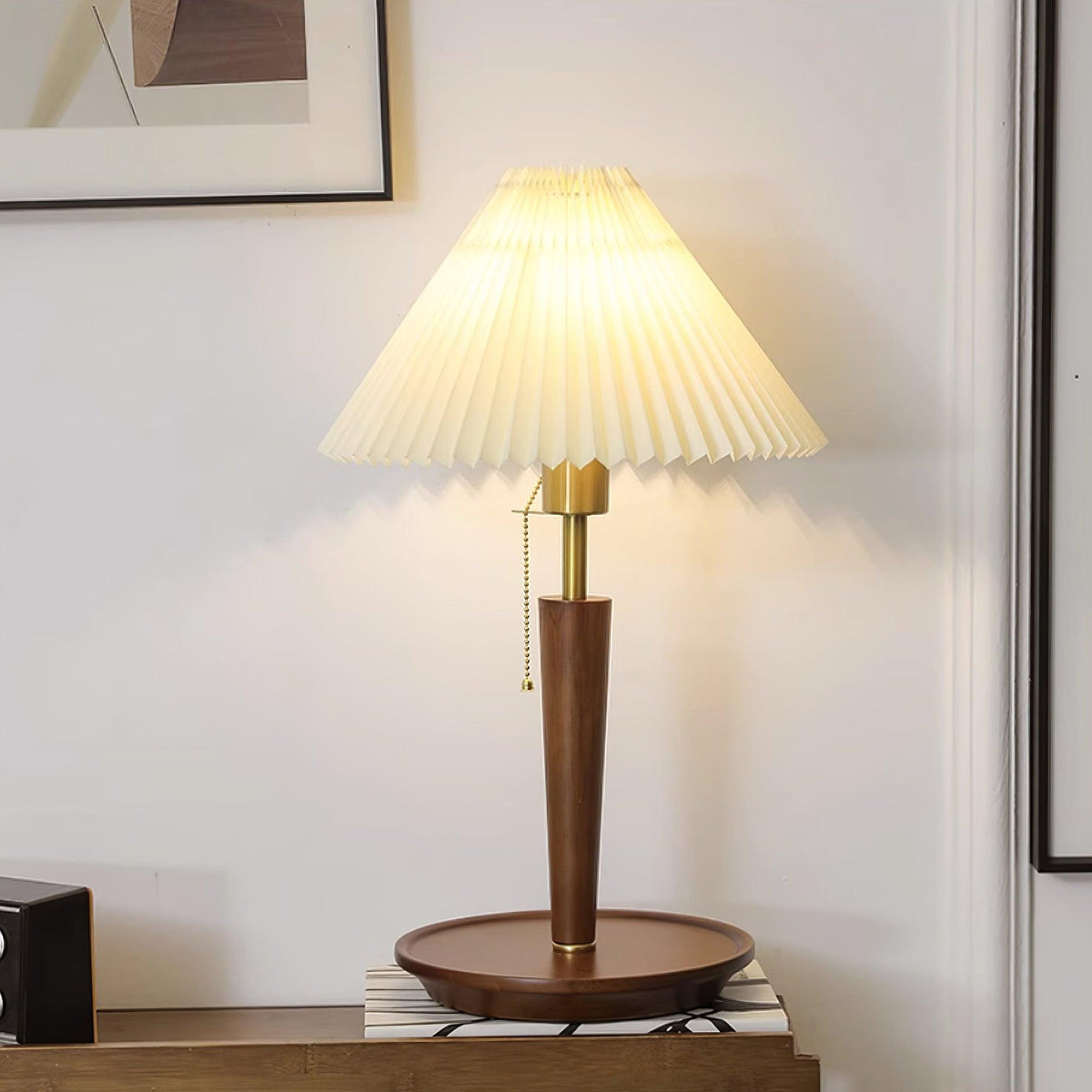 Lámpara de mesa plisada Ripela – encendida sobre una cómoda