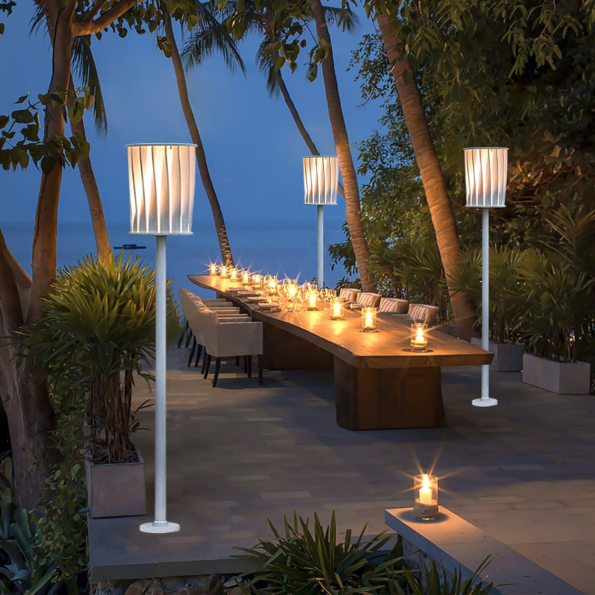 Lámpara de pie exterior Ortiva – iluminando una mesa larga en el jardín