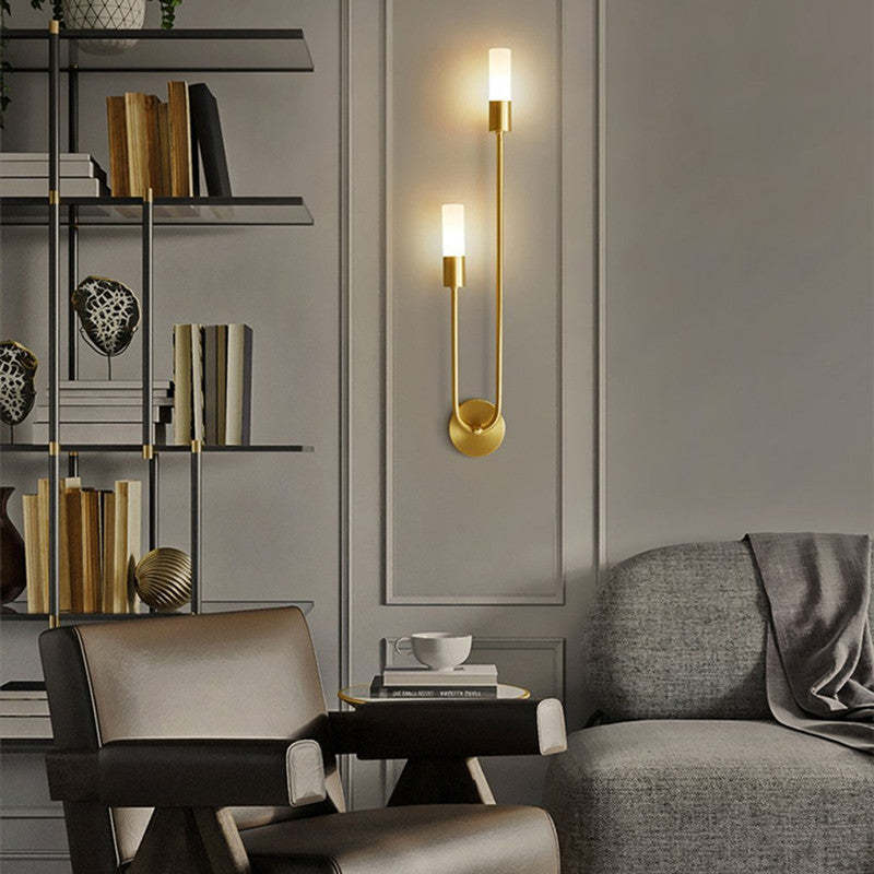 Aplique de pared LED dorado Hilara junto a un cabecero – imagen 5