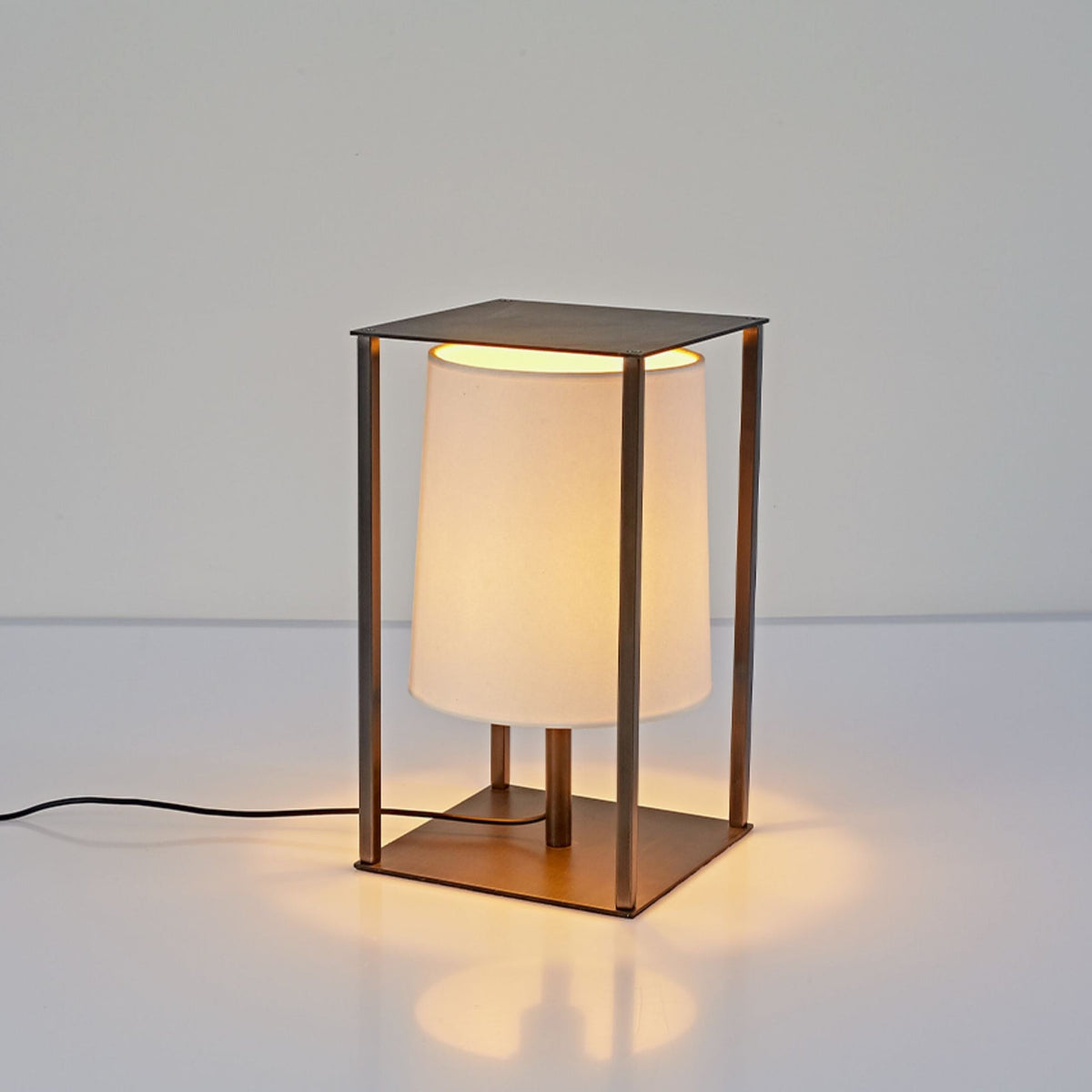 Lámpara de mesa tipo farol de metal negro y papel Farelo – encendida con la pantalla de papel iluminada