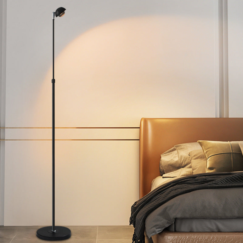 Lámpara de pie minimalista Solvira – negra junto a una cama