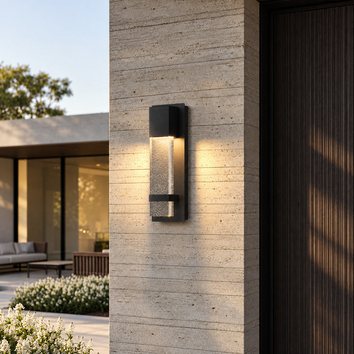 Aplique de pared exterior Yestrela con cristal de burbujas – junto a una puerta de madera en un pilar