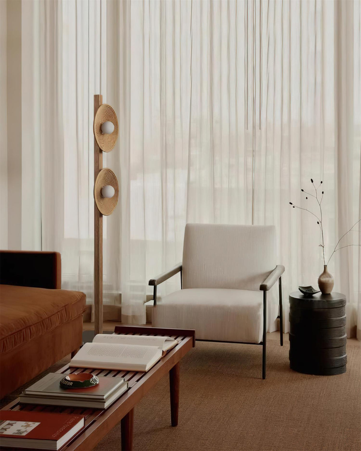 Lámpara de pie de madera con dos discos Radeva – madera natural junto a un sillón