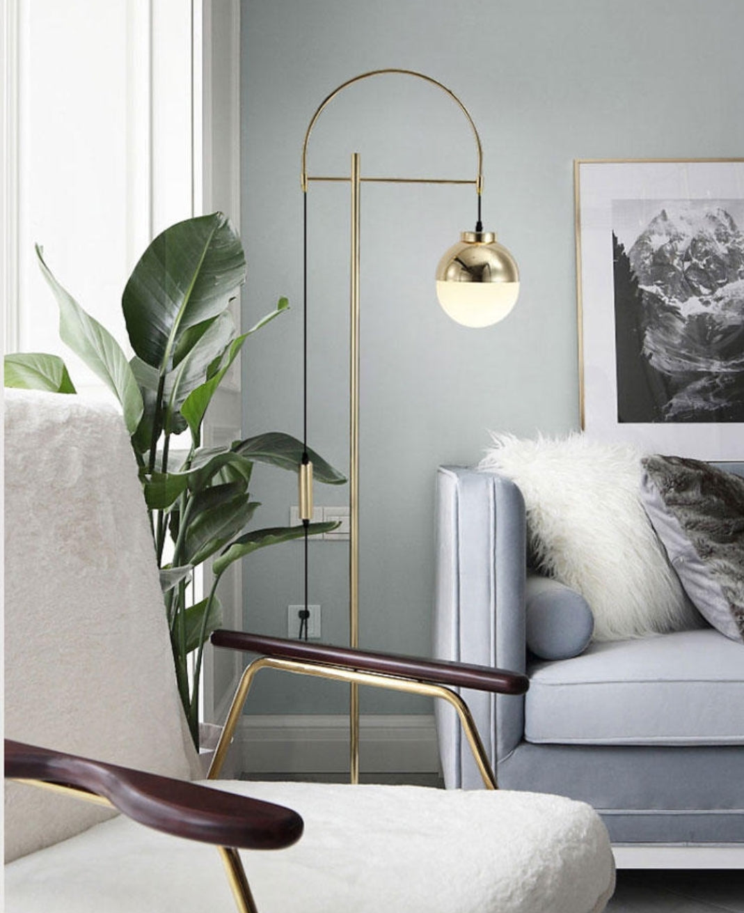 Lámpara de pie arco dorado Solvela – junto a un sillón