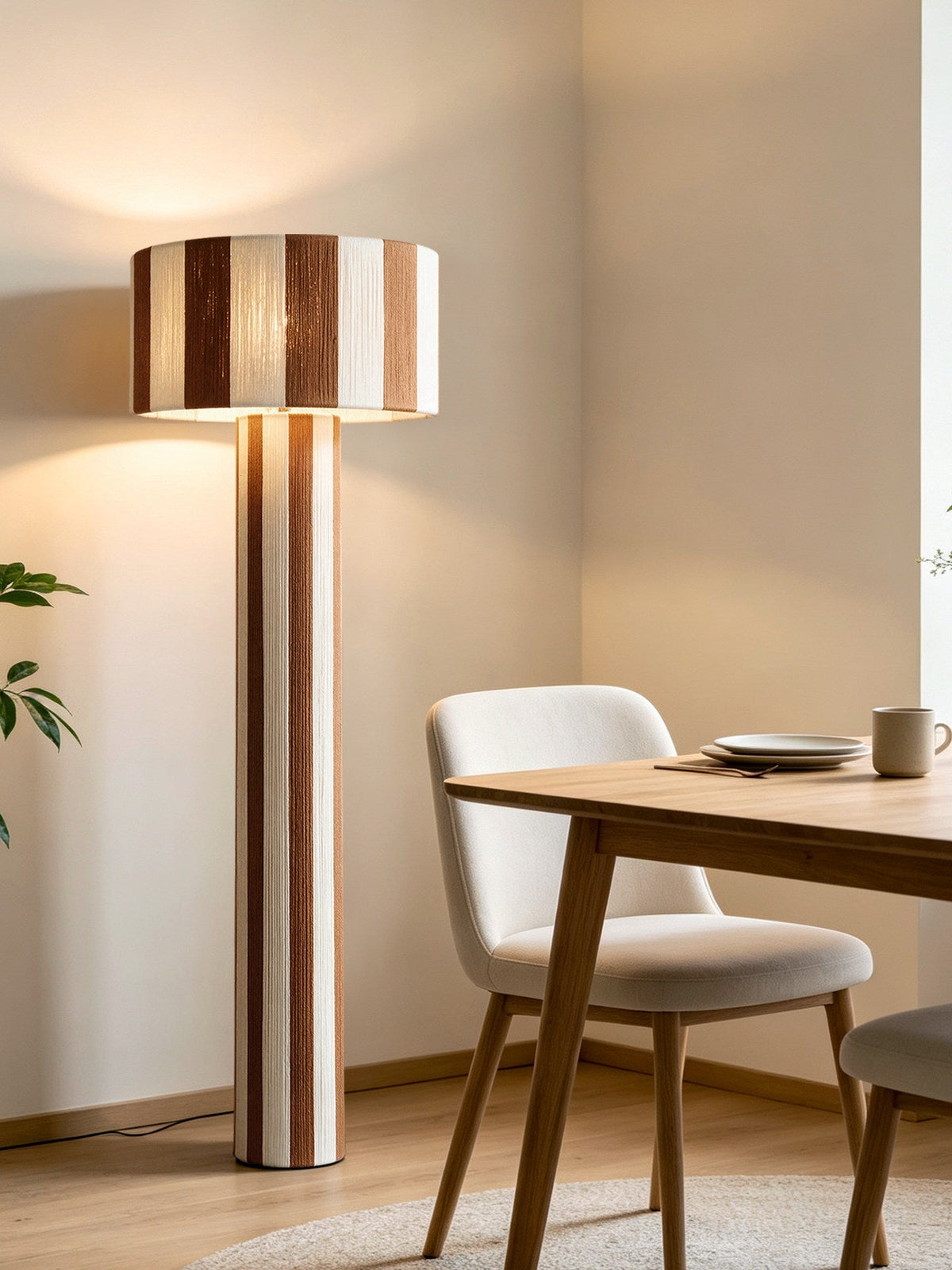 Lámpara de pie columna de hilo a rayas Sombrilda – junto a una mesa de comedor