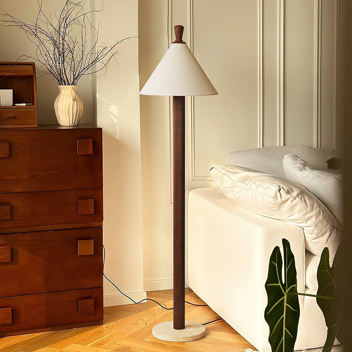 Lámpara de pie de madera y lino Tocana – en nogal junto a una cama