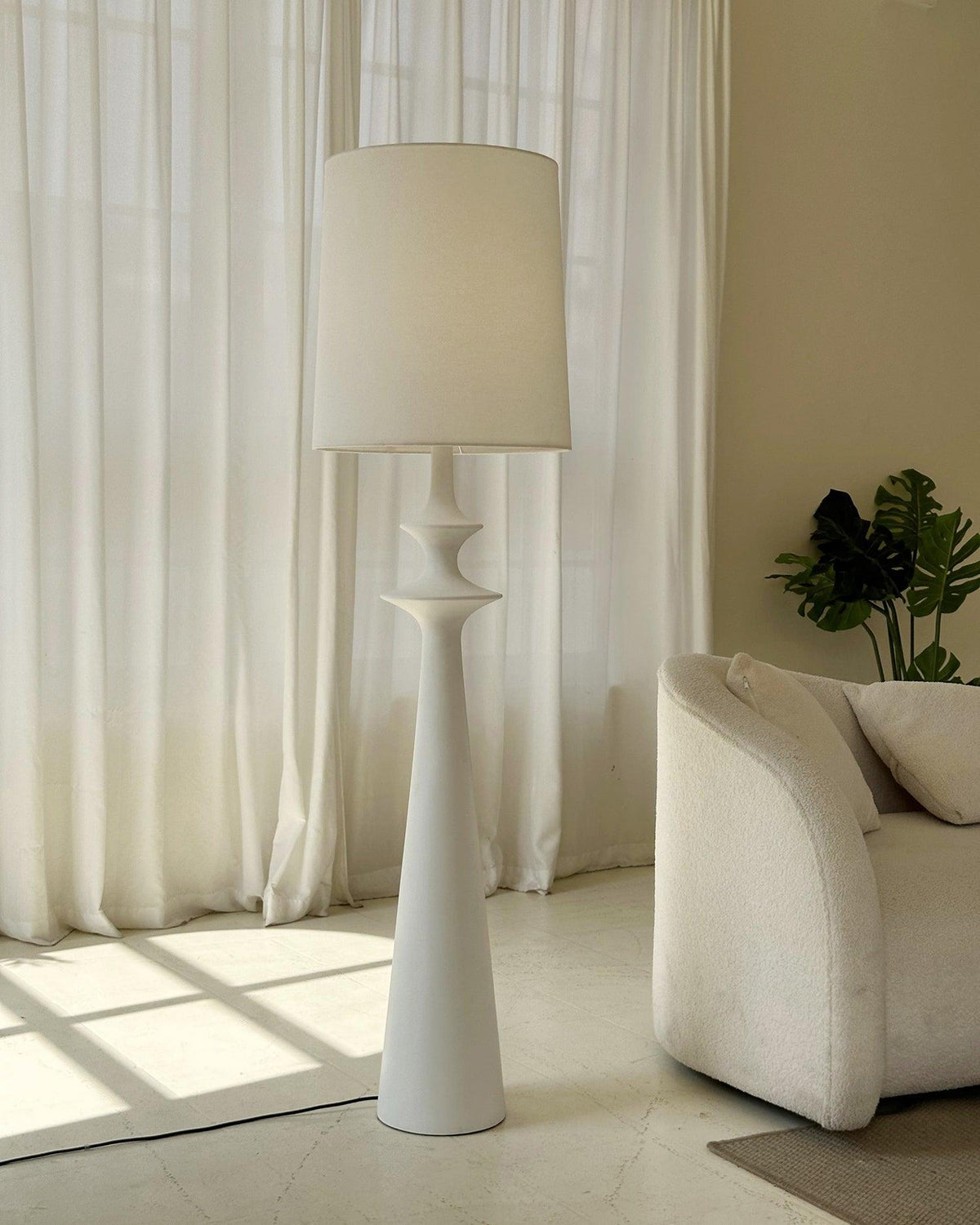 Lámpara de pie columna torneada blanca Tornara en un salón de estilo minimalista – imagen 11