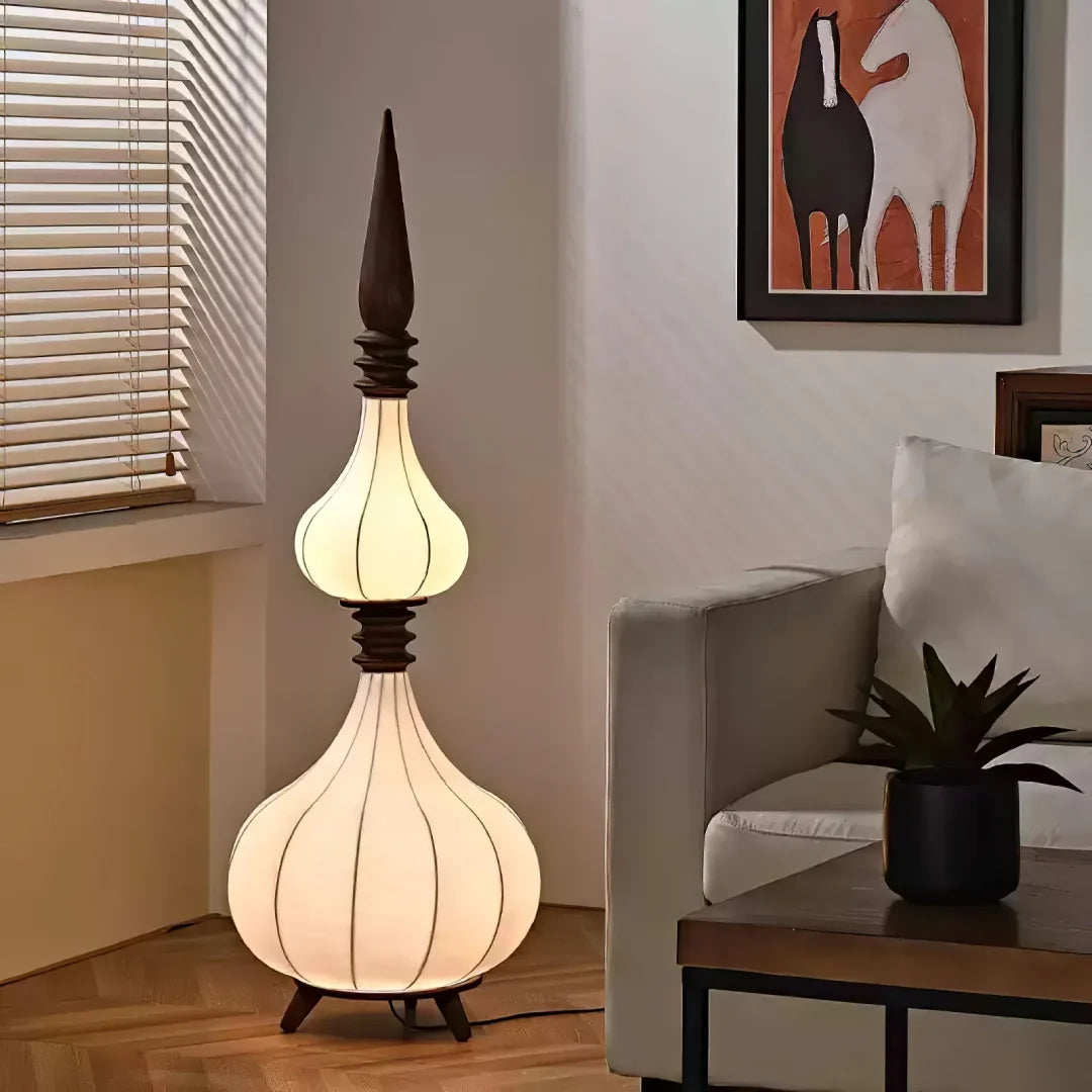 Lámpara de pie de tela y madera Torrina – de un globo grande junto a un sillón
