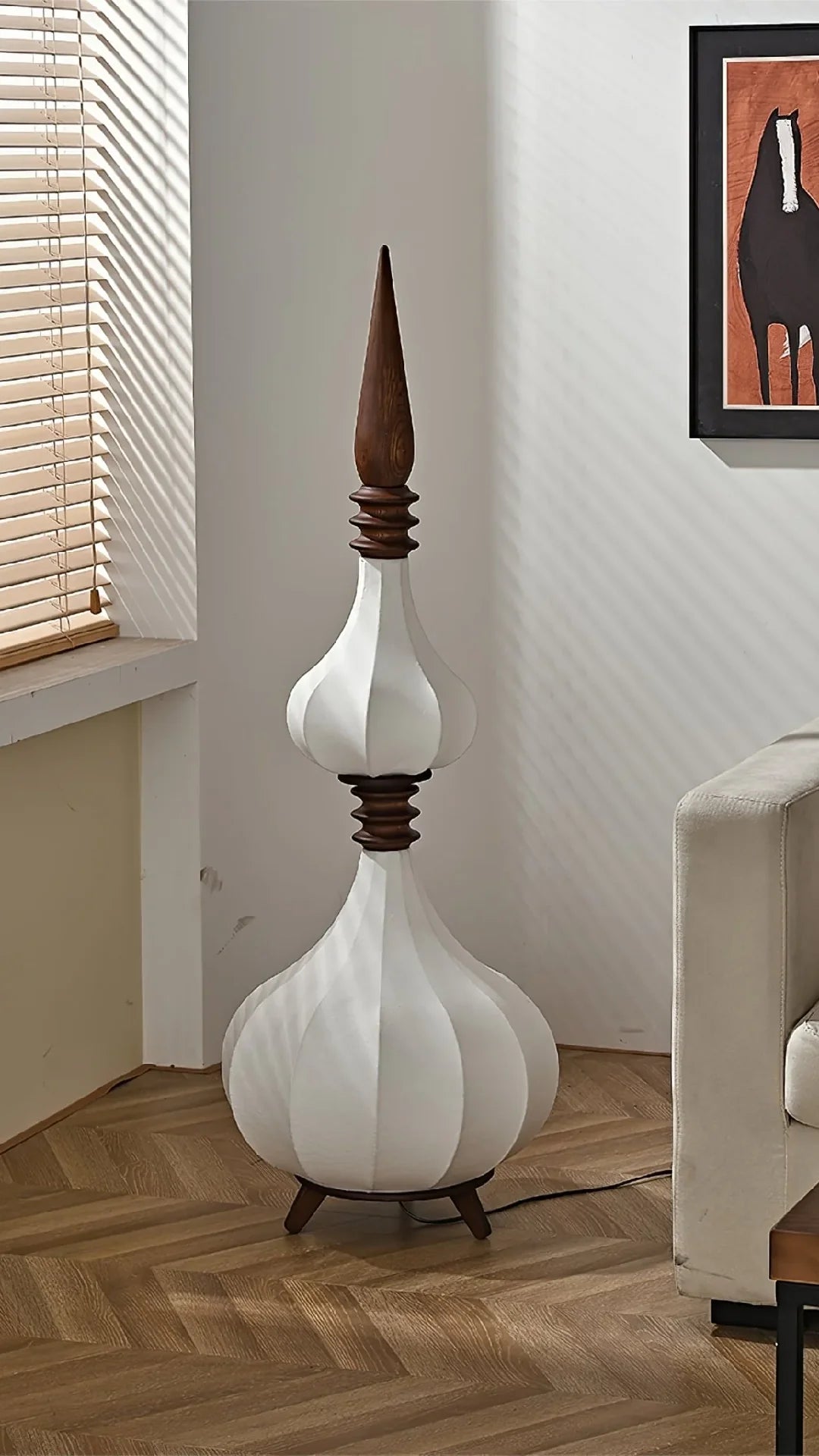 Lámpara de pie de tela y madera Torrina – apagada de un globo junto a un sillón