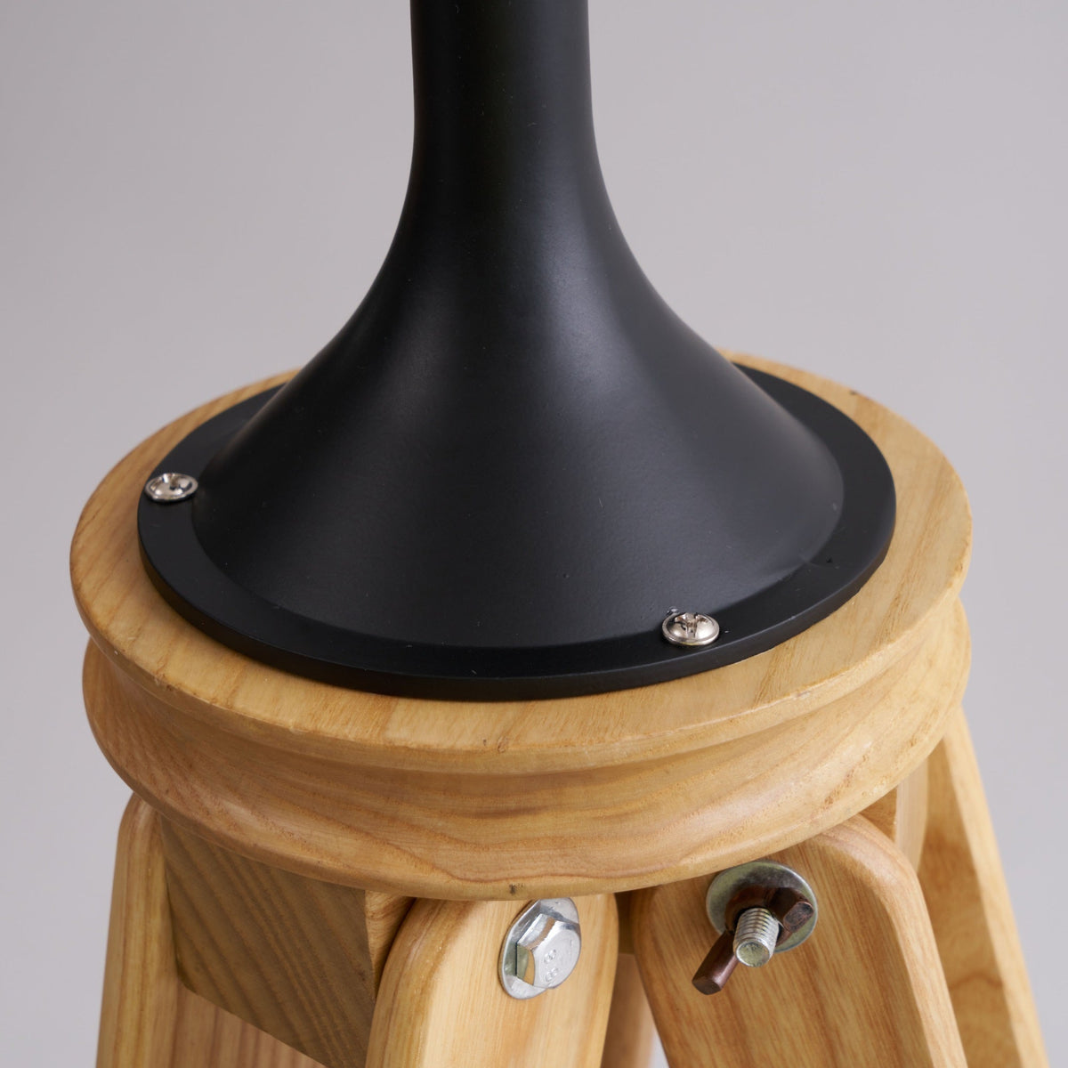 Lámpara de pie trípode con foco Tripola – detalle de la unión de las patas de madera