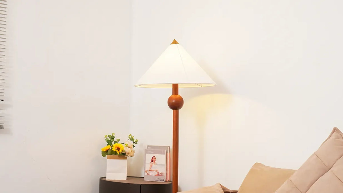 Lámpara de pie de madera Velbora – encendida sobre la mesilla
