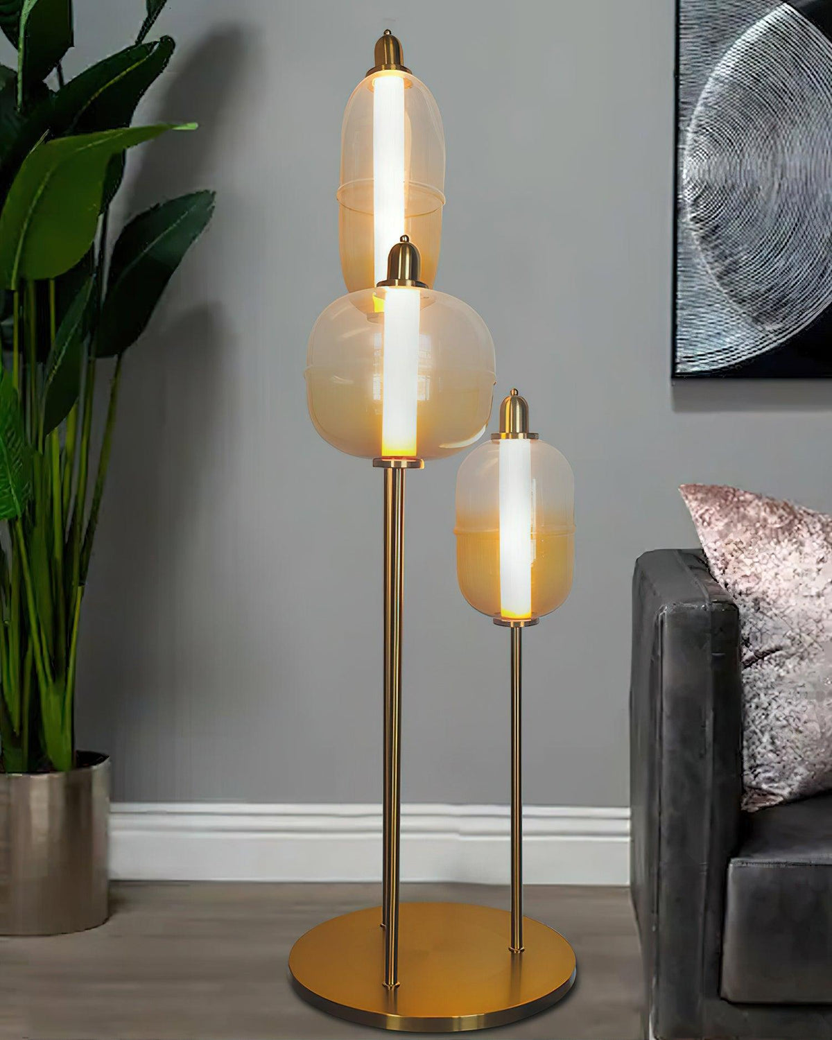 Lámpara de pie LED con cápsulas de vidrio Vidrosa – encendida junto a una planta