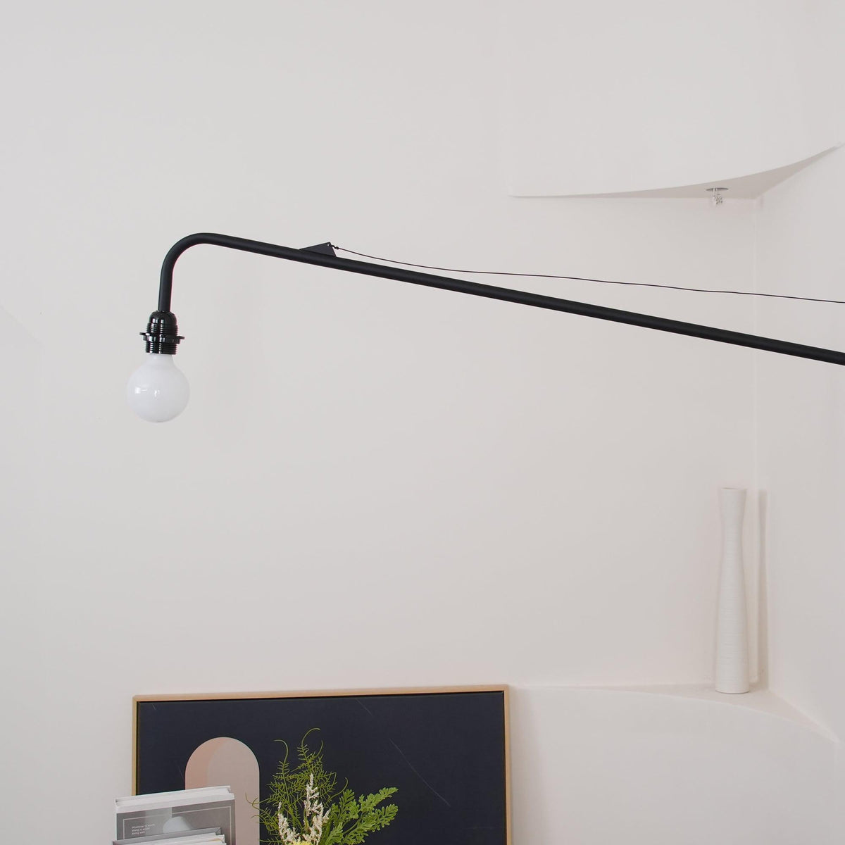 Aplique de pared con brazo largo Vigala sobre un sofá – imagen 19