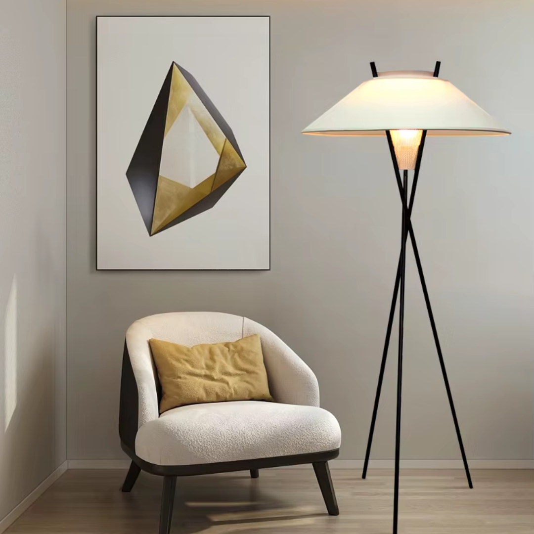 Lámpara de pie trípode Zancala – junto a un sillón y un cuadro