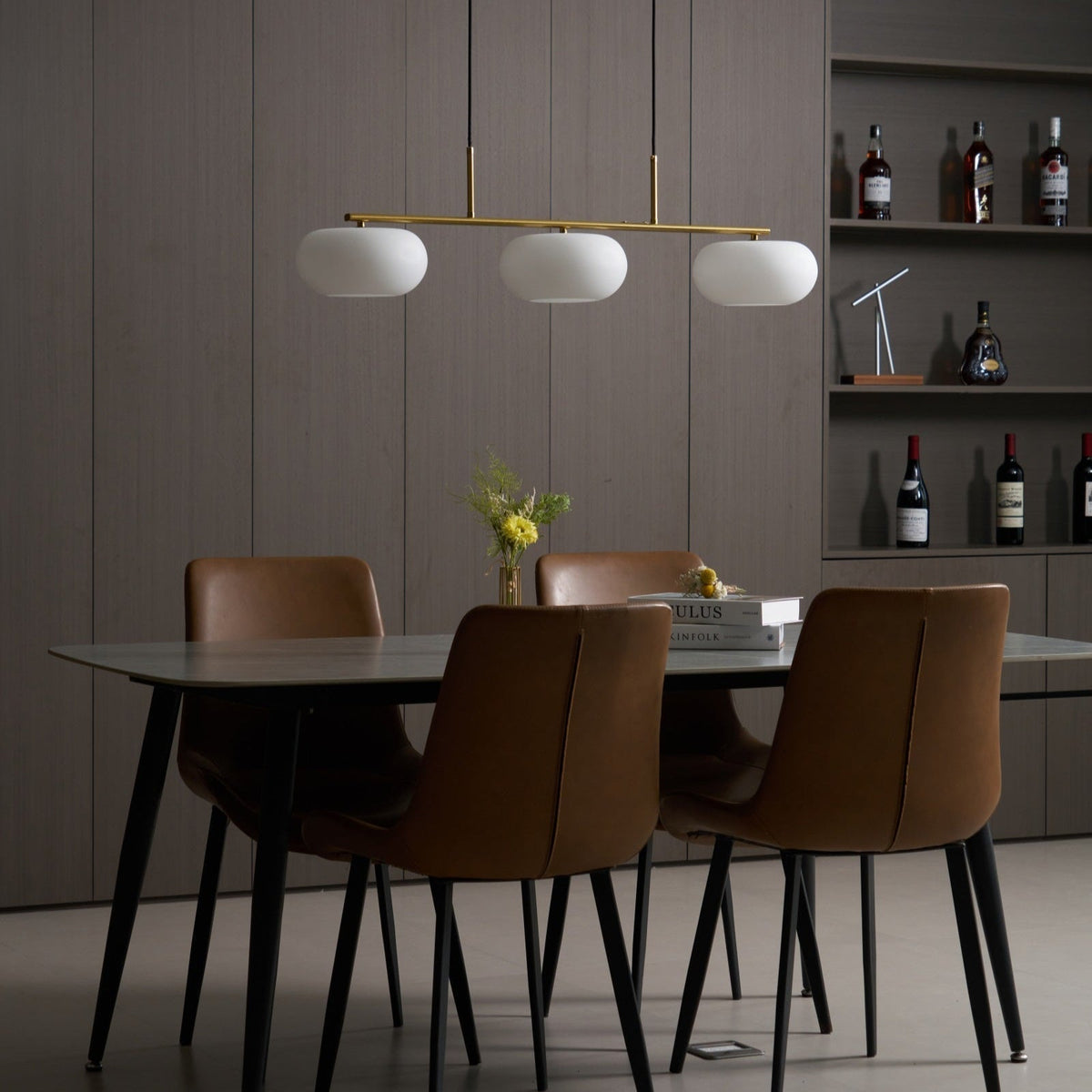 Lámpara colgante lineal Calima – dorada en un comedor moderno