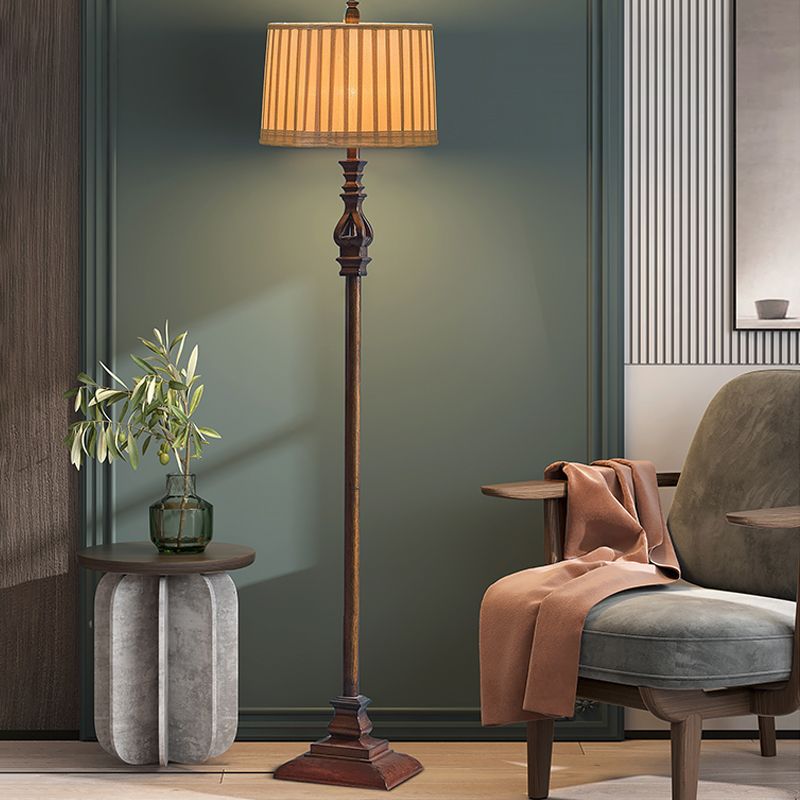 Lámpara de pie clásica marrón con pantalla plisada Jaseda – junto a un sillón y una mesita en un salón