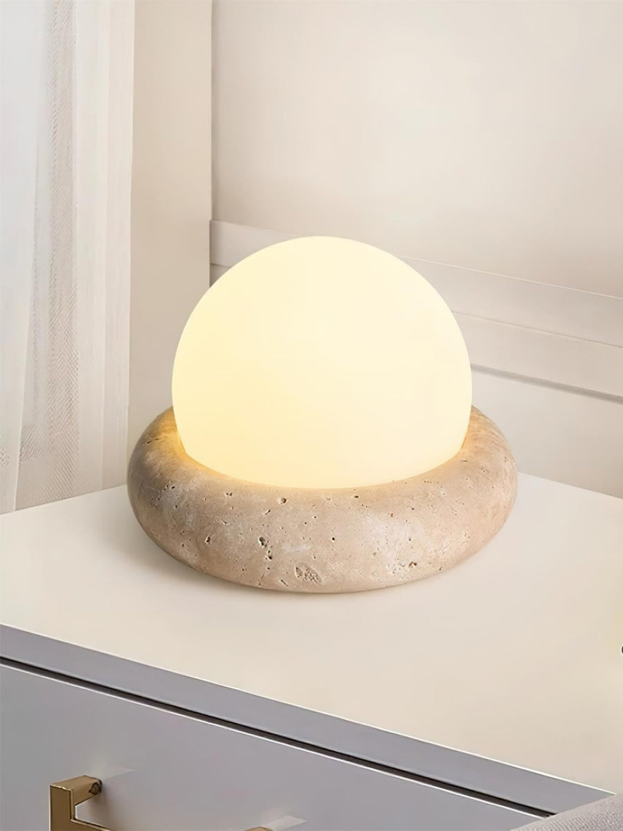Lámpara de mesa de travertino Ocrina sobre una mesita de noche – imagen 2