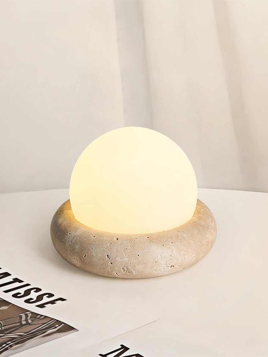 Lámpara de mesa de travertino Ocrina sobre una mesita de noche – imagen 3