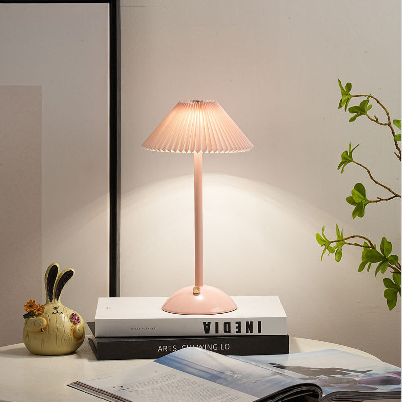 Lámpara de mesa recargable Delisa con pantalla plisada sobre una mesita – imagen 22