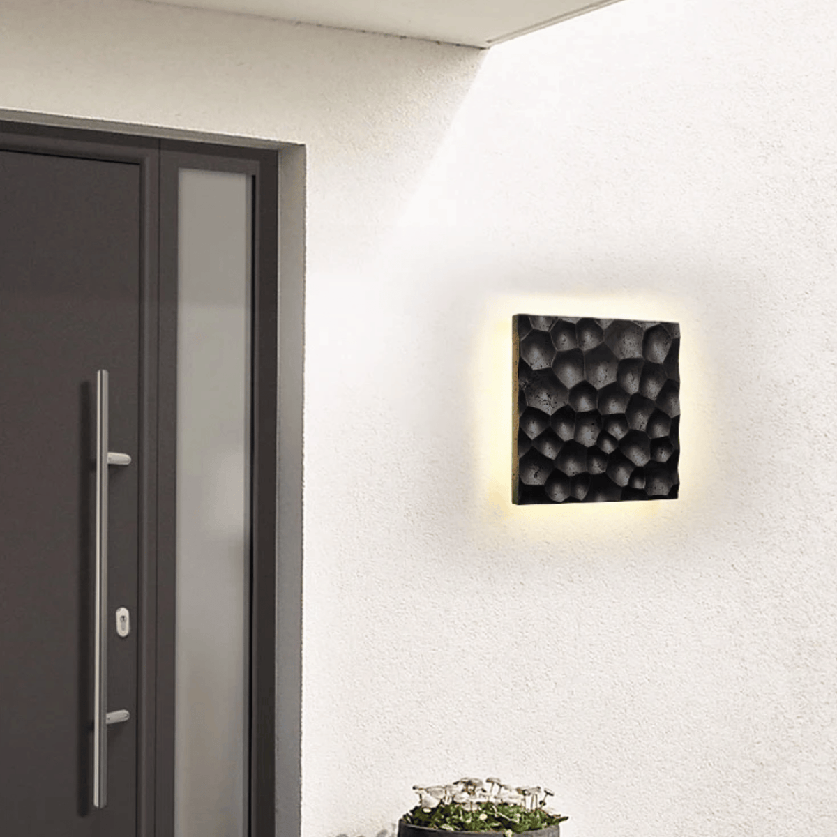Aplique de pared de piedra natural Ituria – negro junto a la puerta de entrada