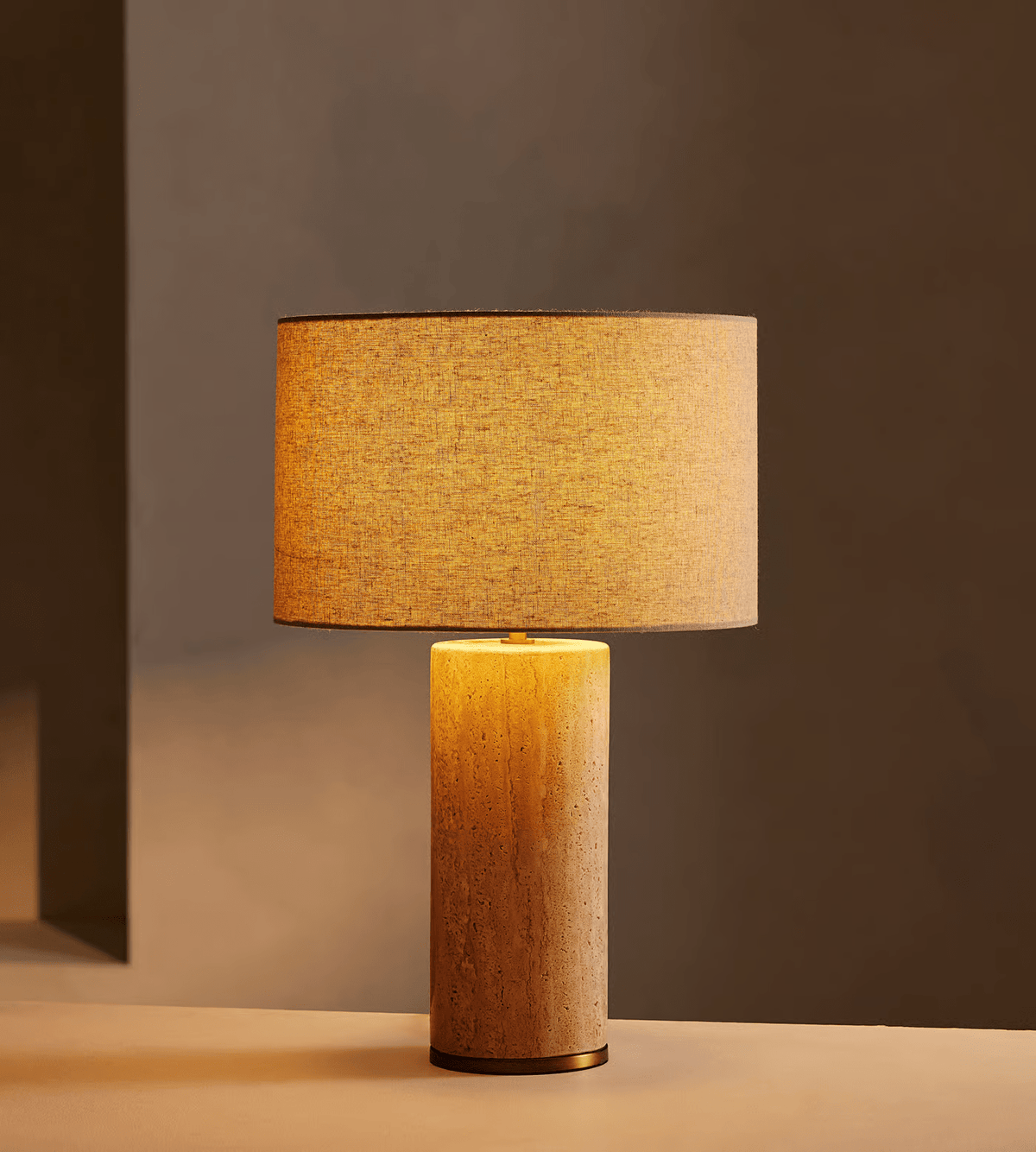 Lámpara de mesa de travertino con pantalla beige Hontera – encendida con luz cálida