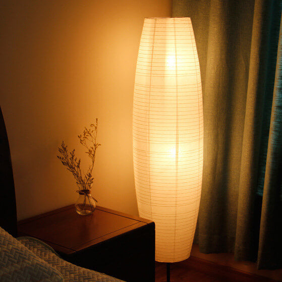Lámpara de pie de papel estilo farol Velarda – encendida junto a una cortina verde