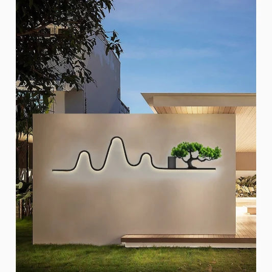 Aplique de pared exterior Jemonta – en el muro de un jardín al atardecer